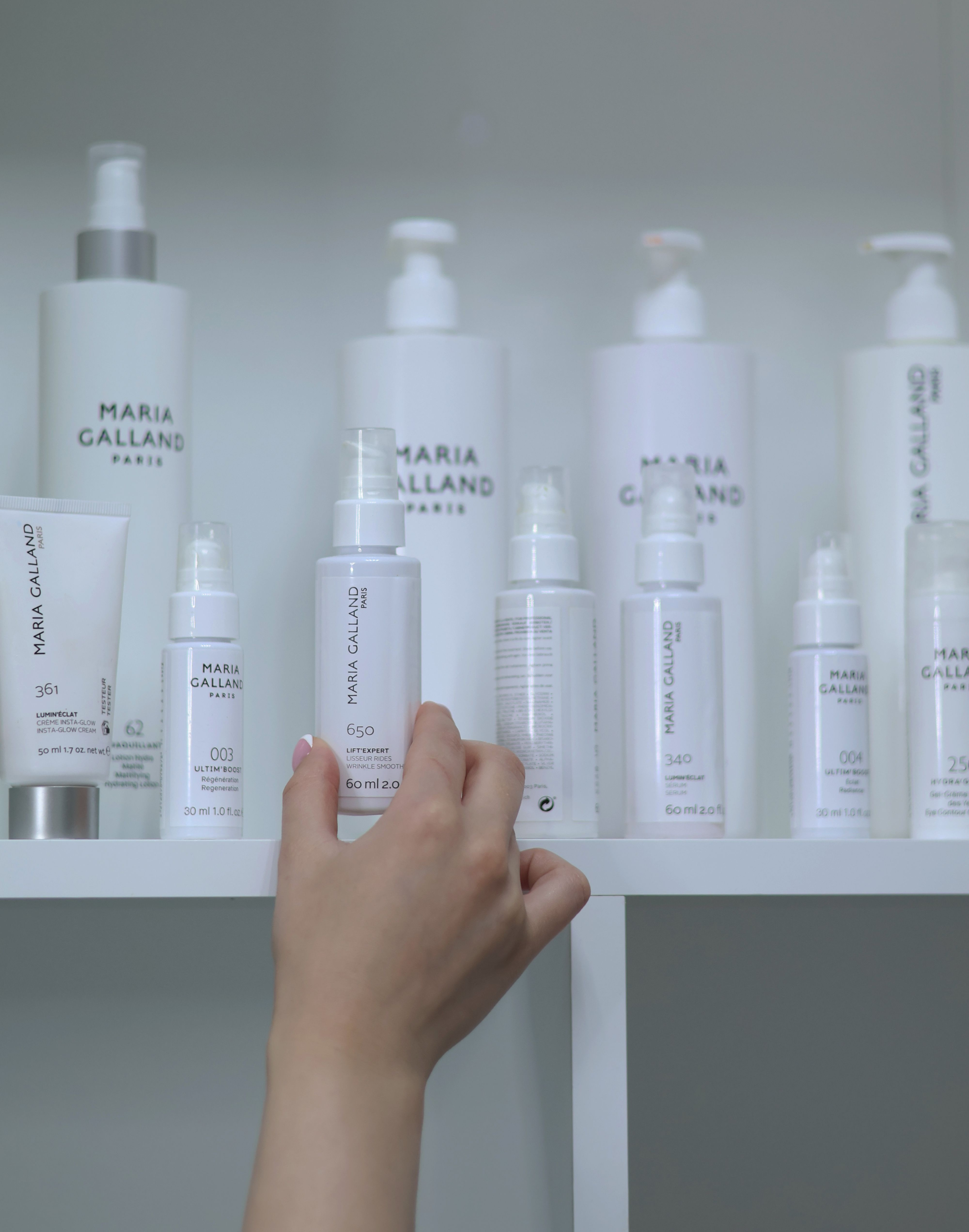 Minimal skincare bottles arranged in soft bathroom light